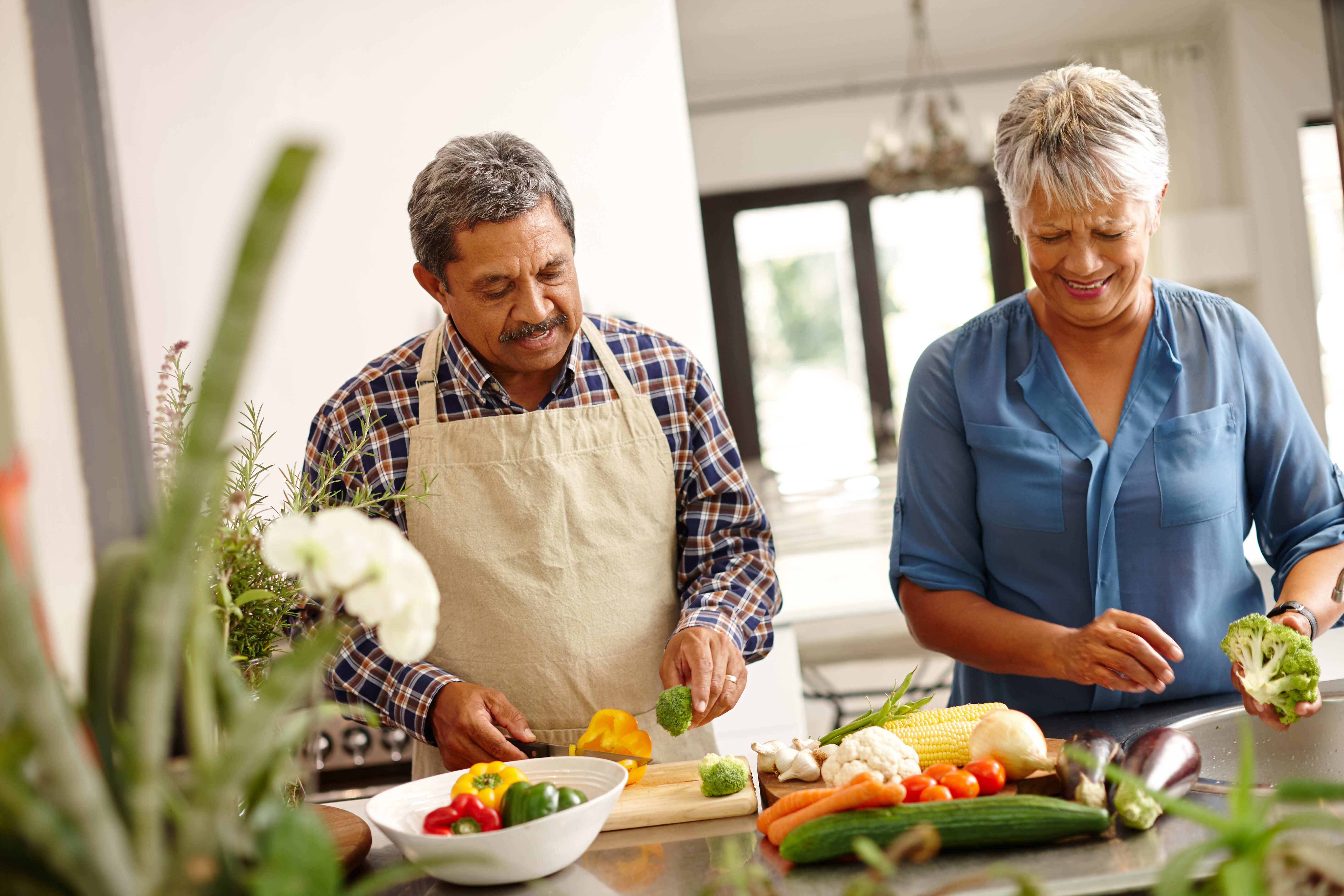 Pareja corta verduras en una cocina